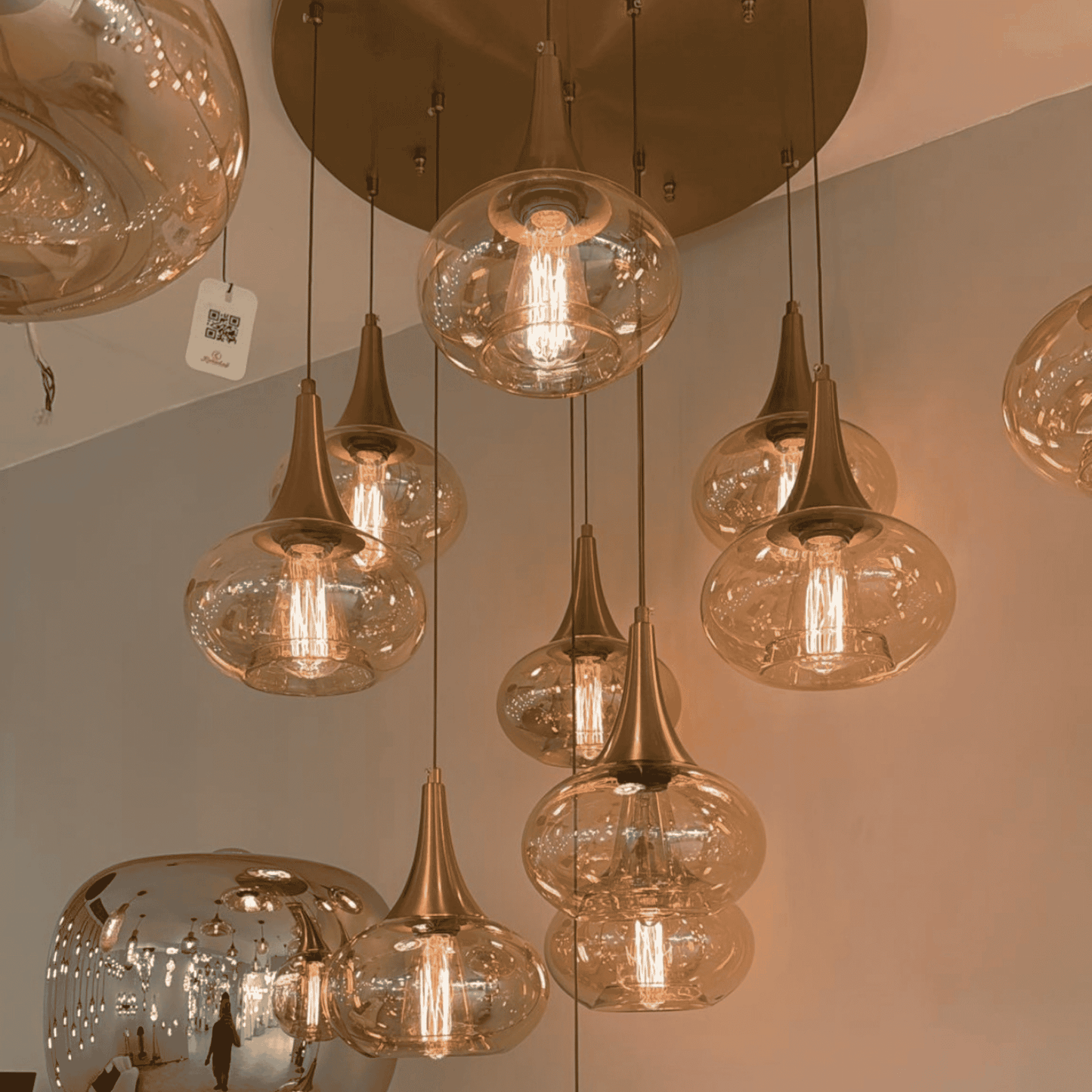 Amber pendant lights with warm bulbs and bronze ceiling mount in a modern interior.