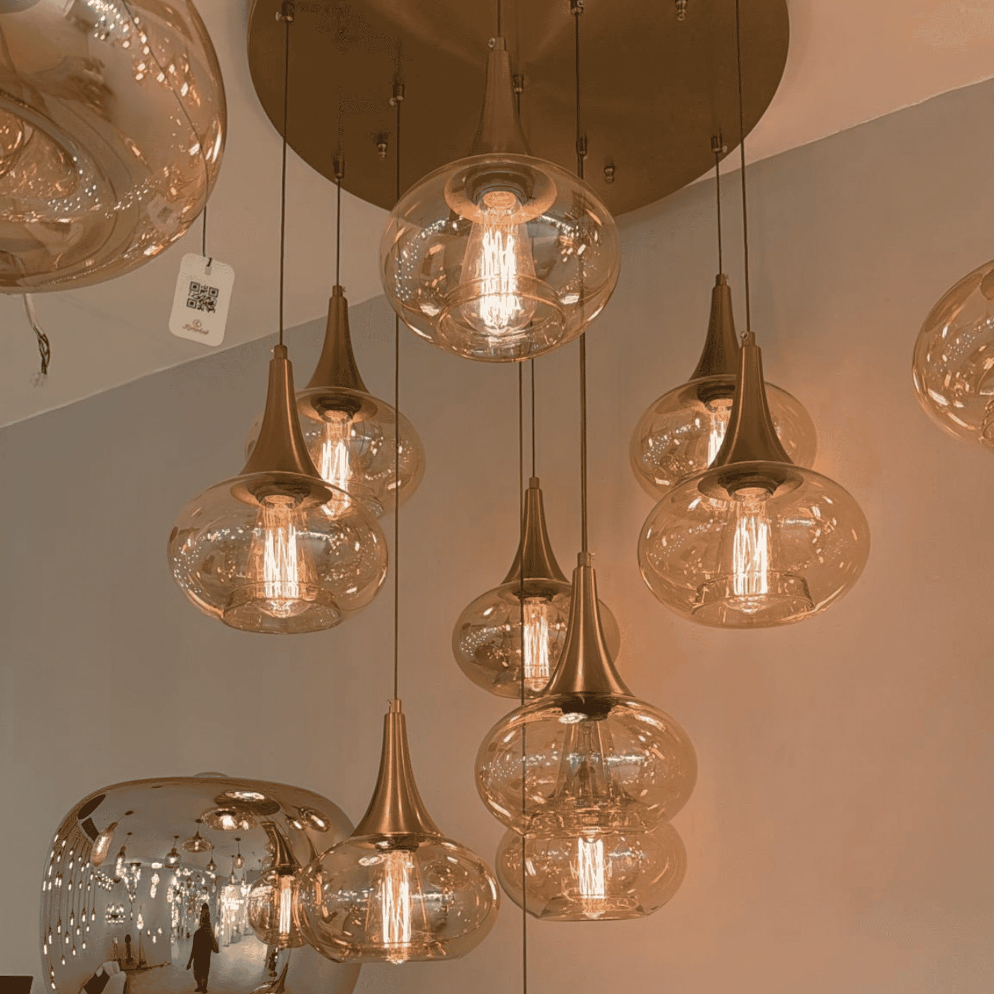 Amber pendant lights with warm bulbs and bronze ceiling mount in a modern interior.