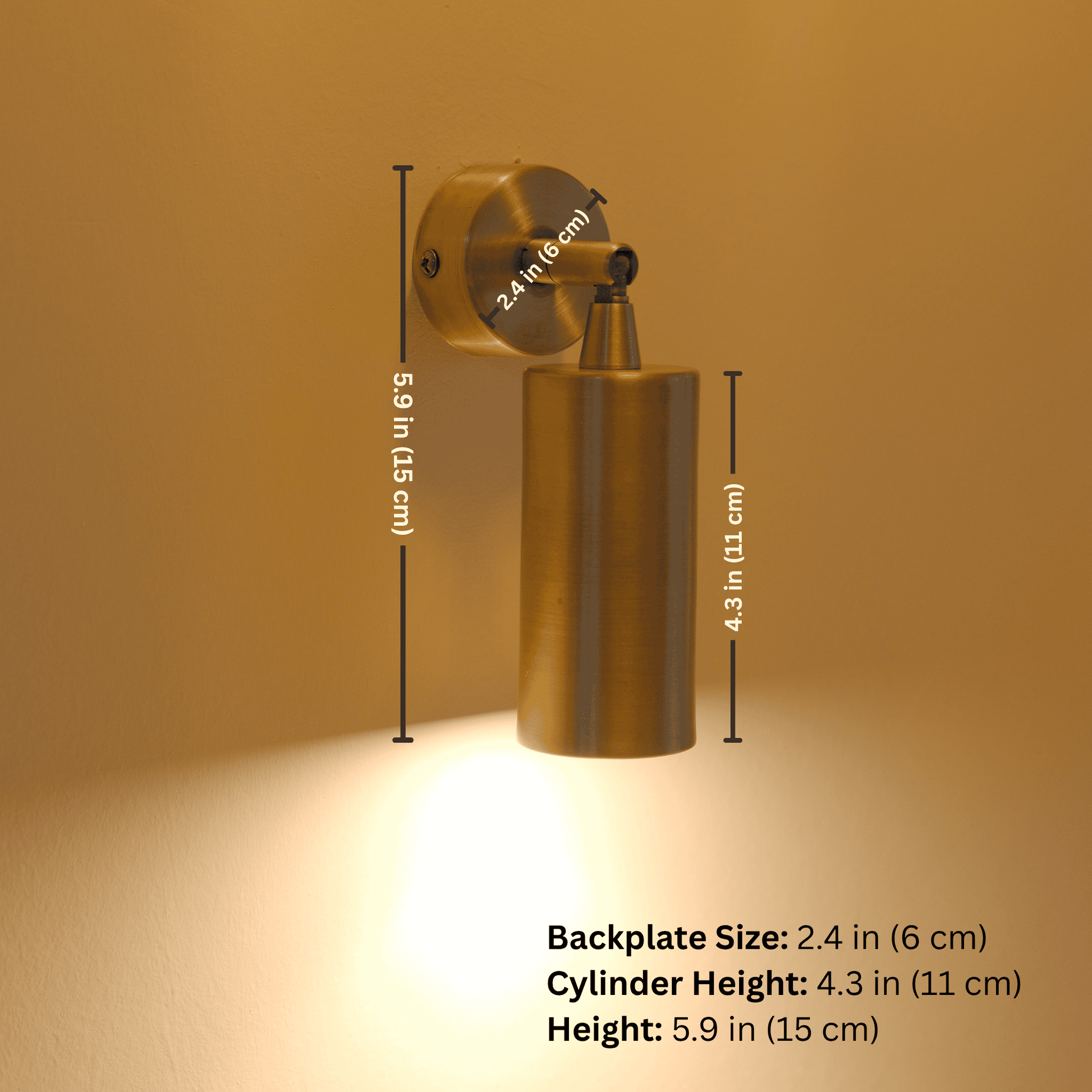 Brass cylinder wall sconce with warm downlight, shown mounted on wall with backplate, cylinder, and full height measurements labeled.
