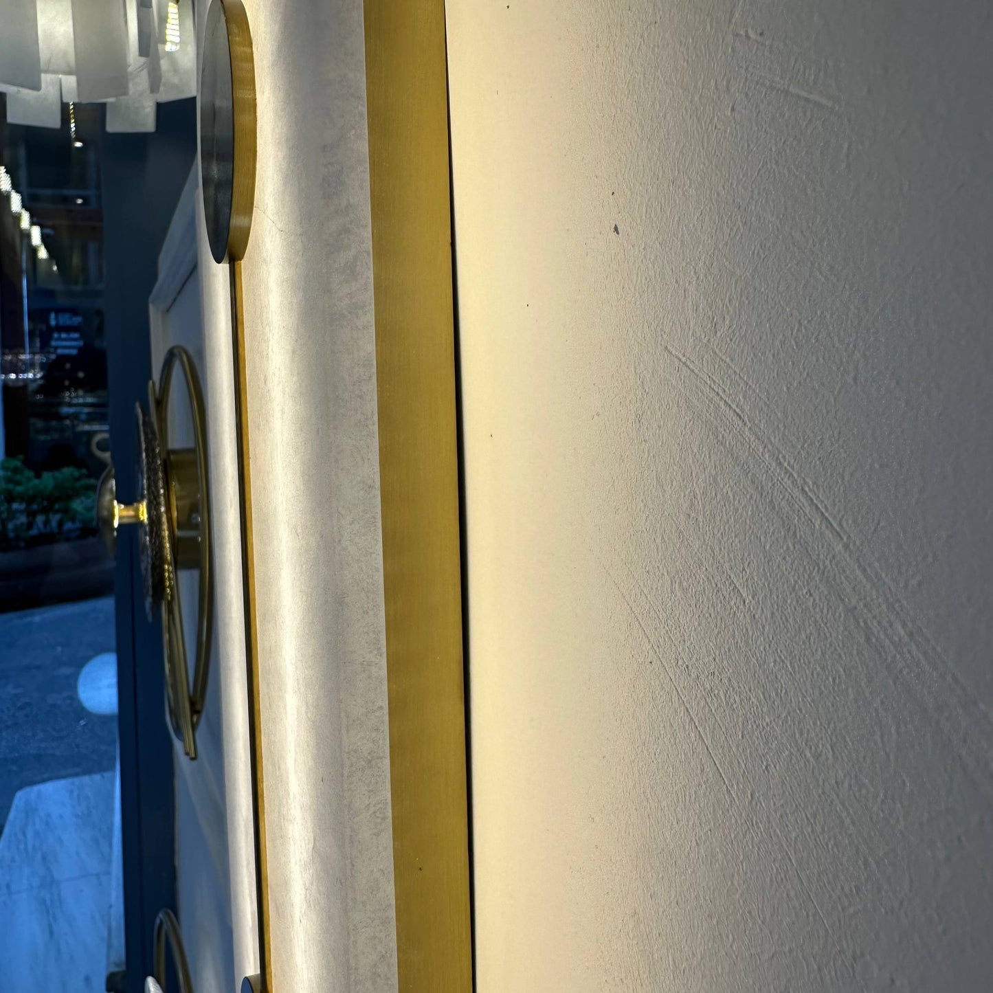 Side view of alabaster wall light fixture with brass frame and subtle glow.