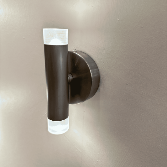 Brushed metal LED wall sconce with cylindrical design and frosted acrylic ends, ideal for stylish modern interior lighting.