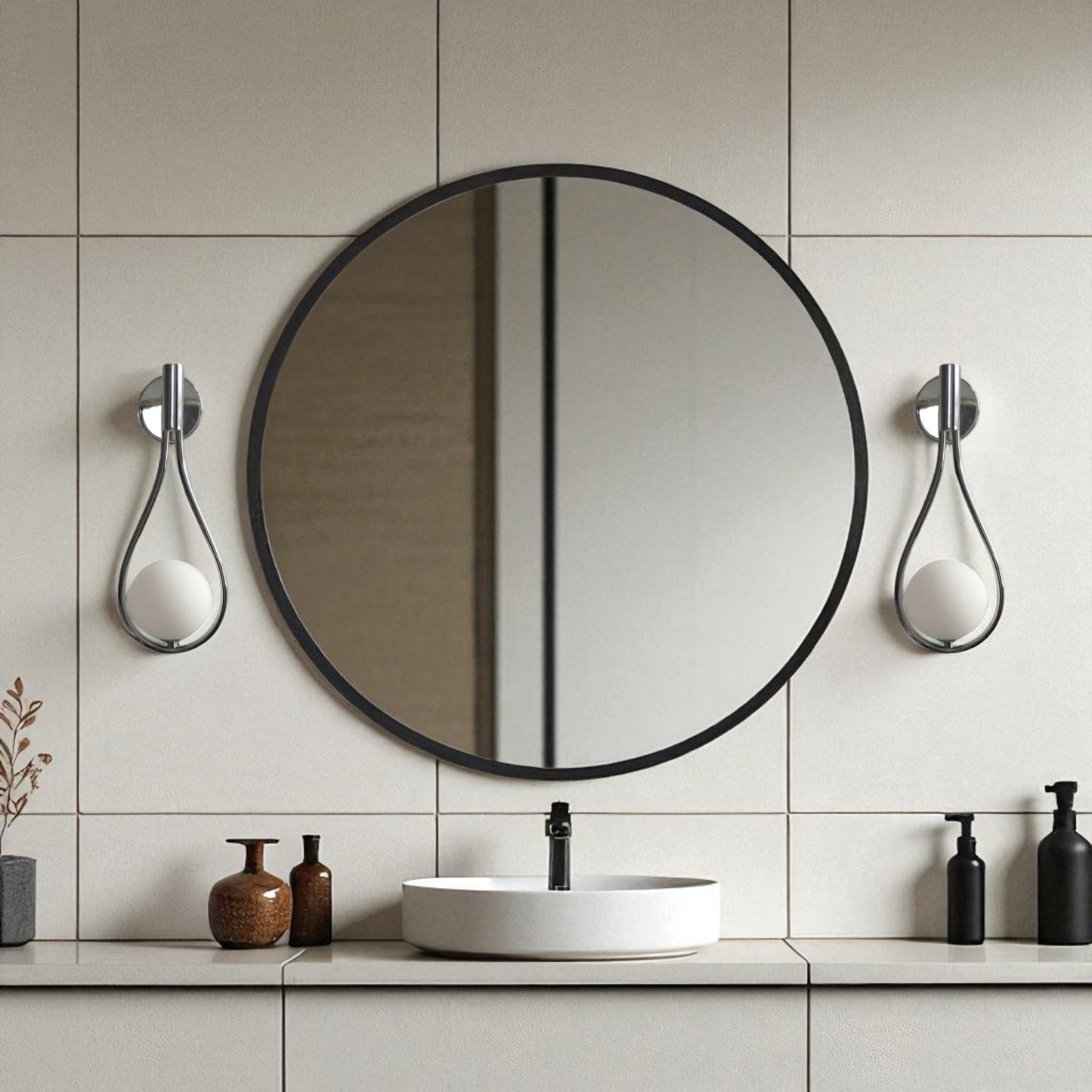 Chrome teardrop wall sconces on each side of a round mirror in a minimalist modern bathroom vanity setup.