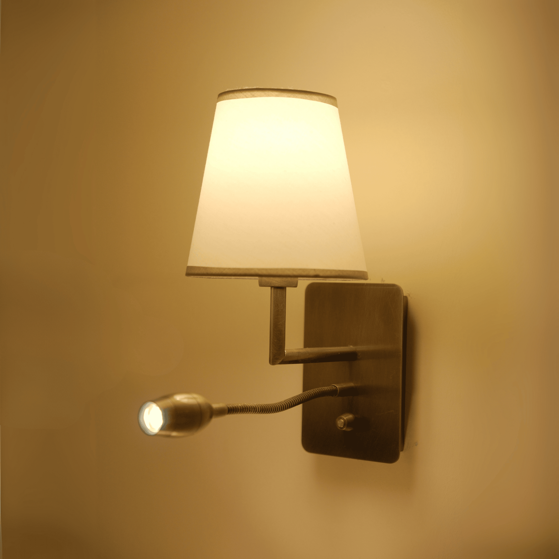 Classic wall sconce with warm lighting and articulated reading light beneath a white shade.