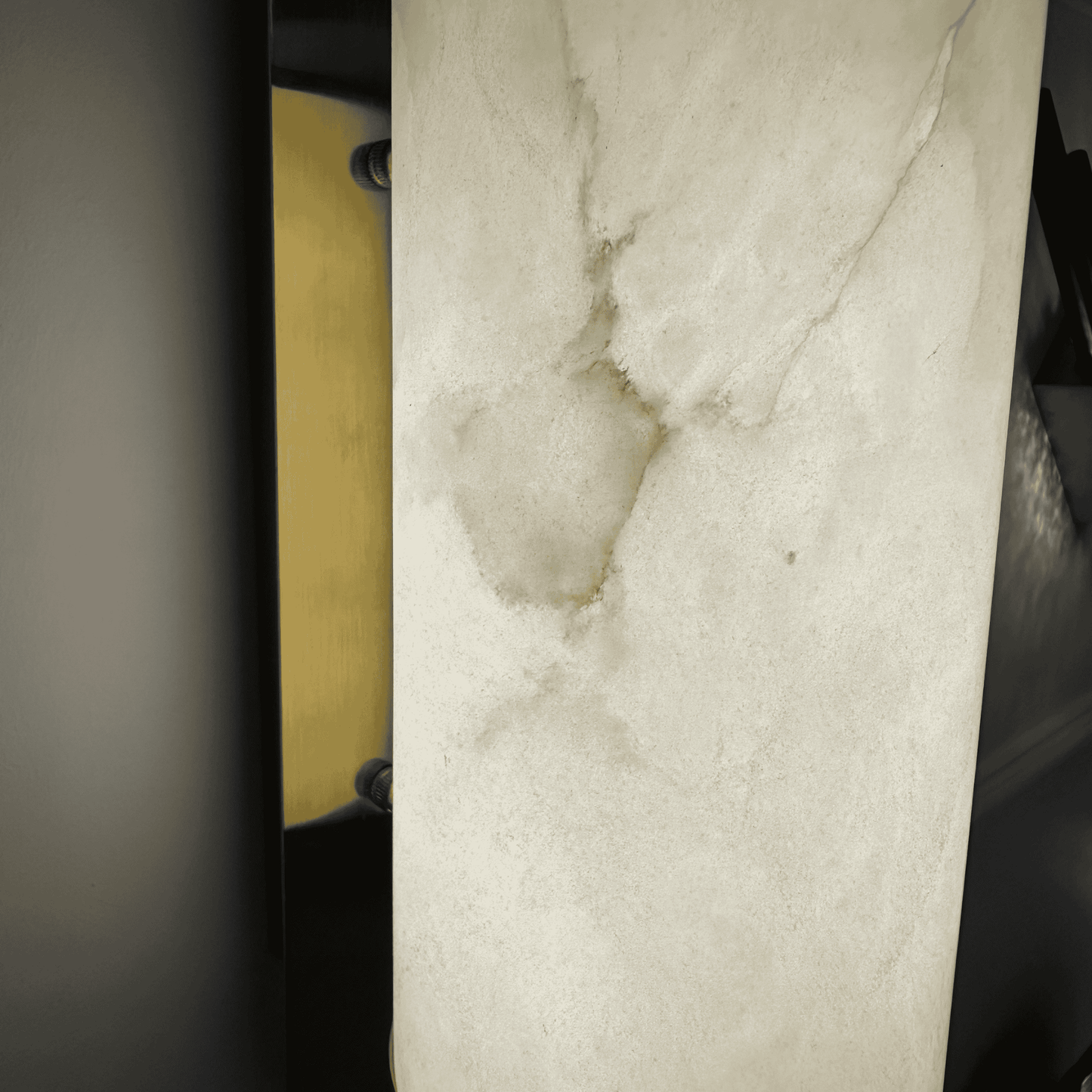 Detailed close-up of alabaster wall sconce showing texture and brass hardware.