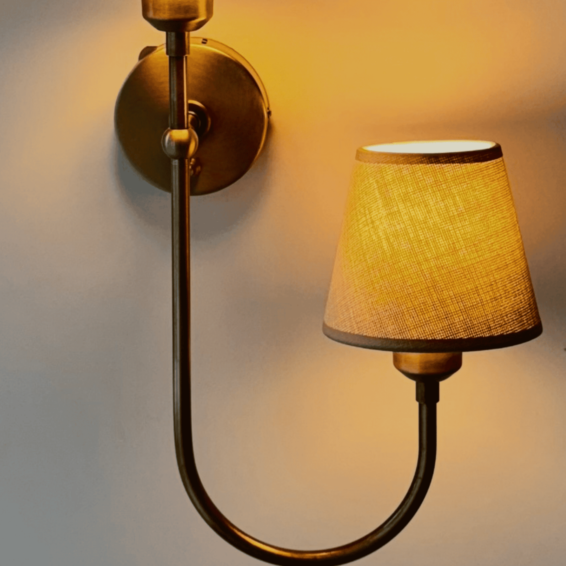 Close-up of dual-shade wall sconce with warm fabric shade light, mounted on a wall