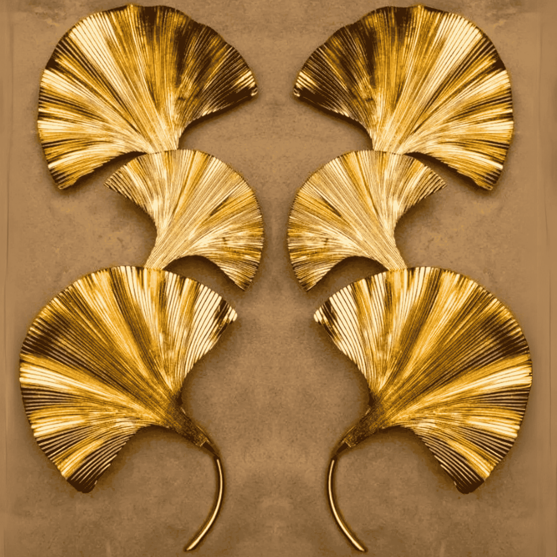 Botanical brass wall sconce with three ginkgo leaf forms glowing on a black paneled surface