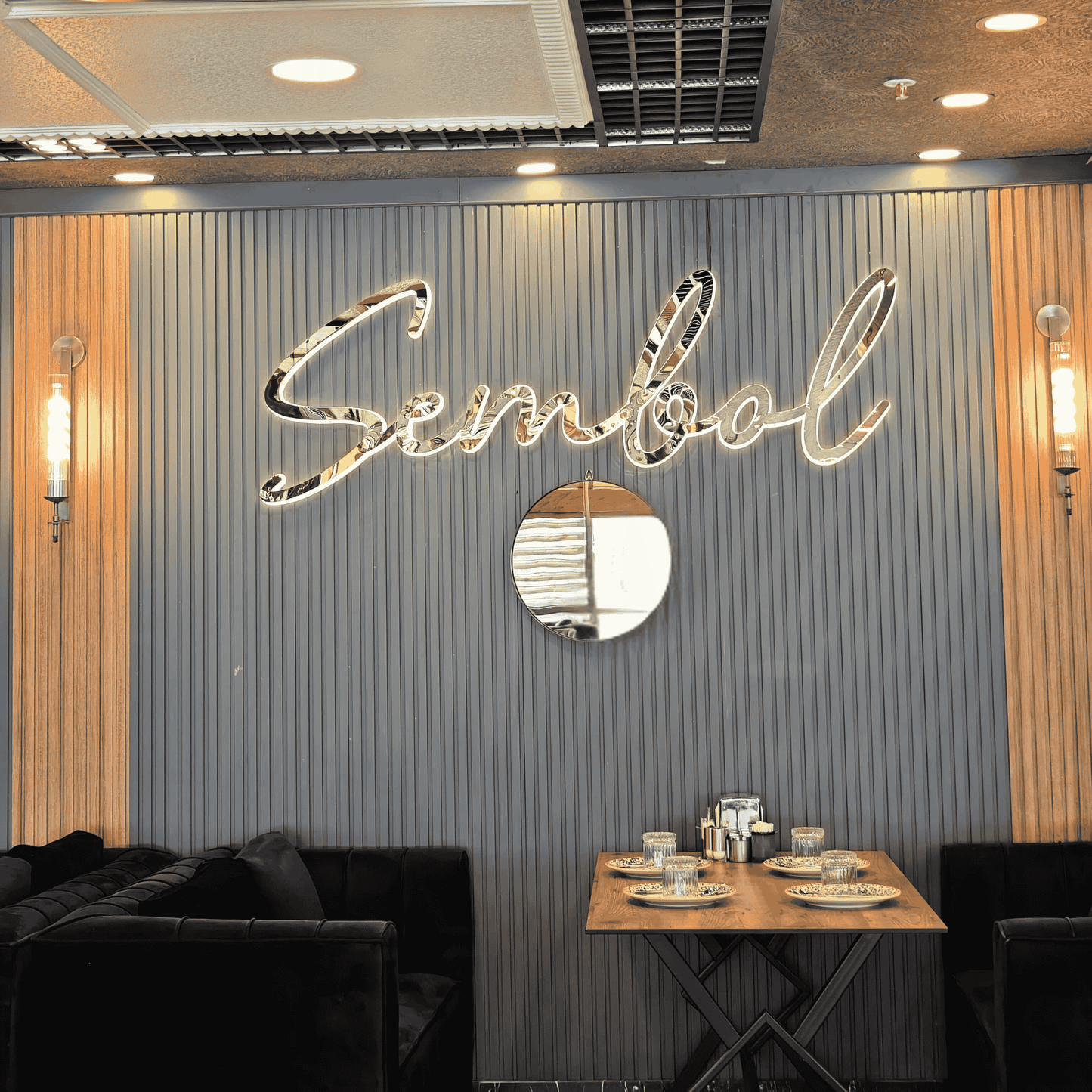 Brass ribbed wall sconces installed on a decorative restaurant wall behind a dining booth