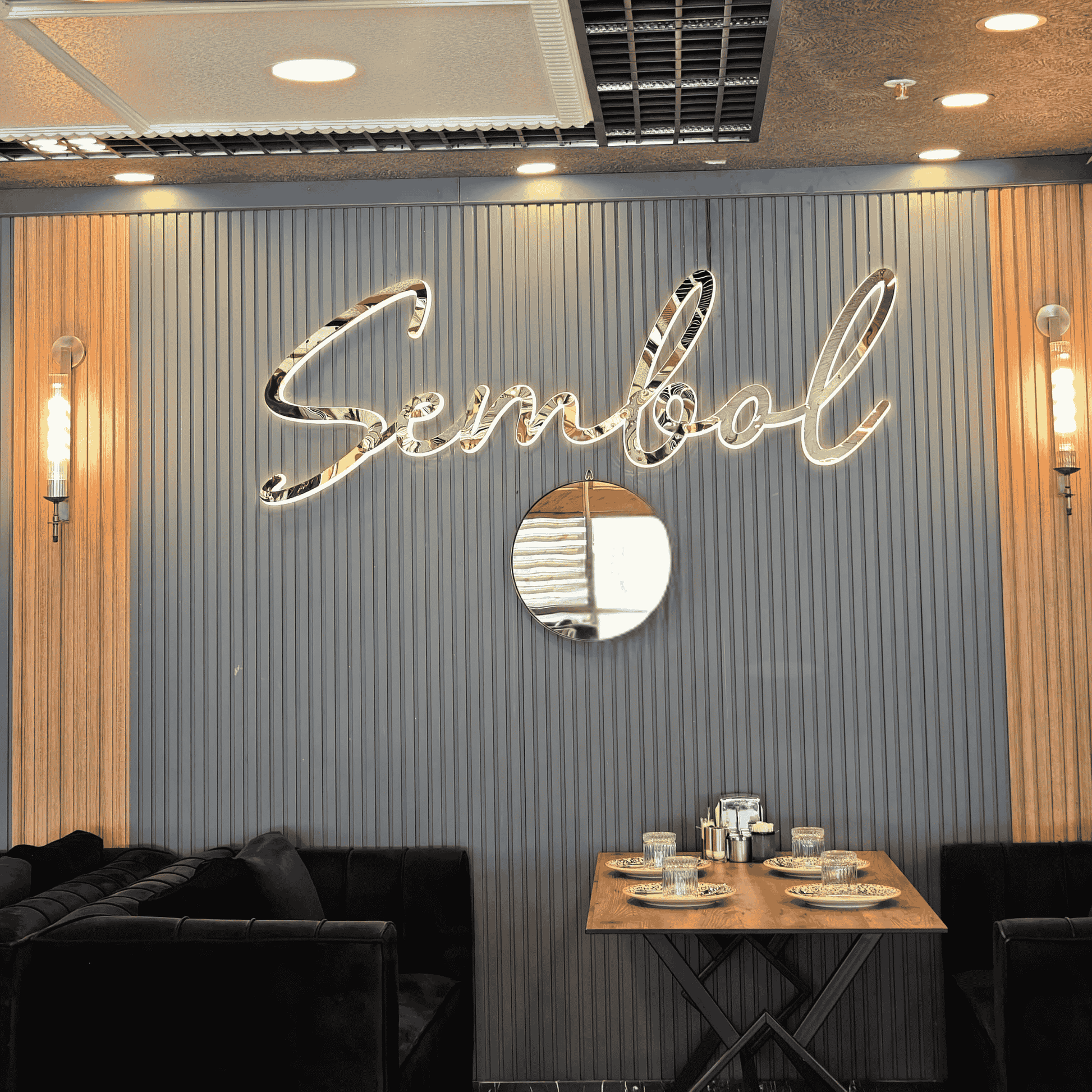 Brass ribbed wall sconces installed on a decorative restaurant wall behind a dining booth