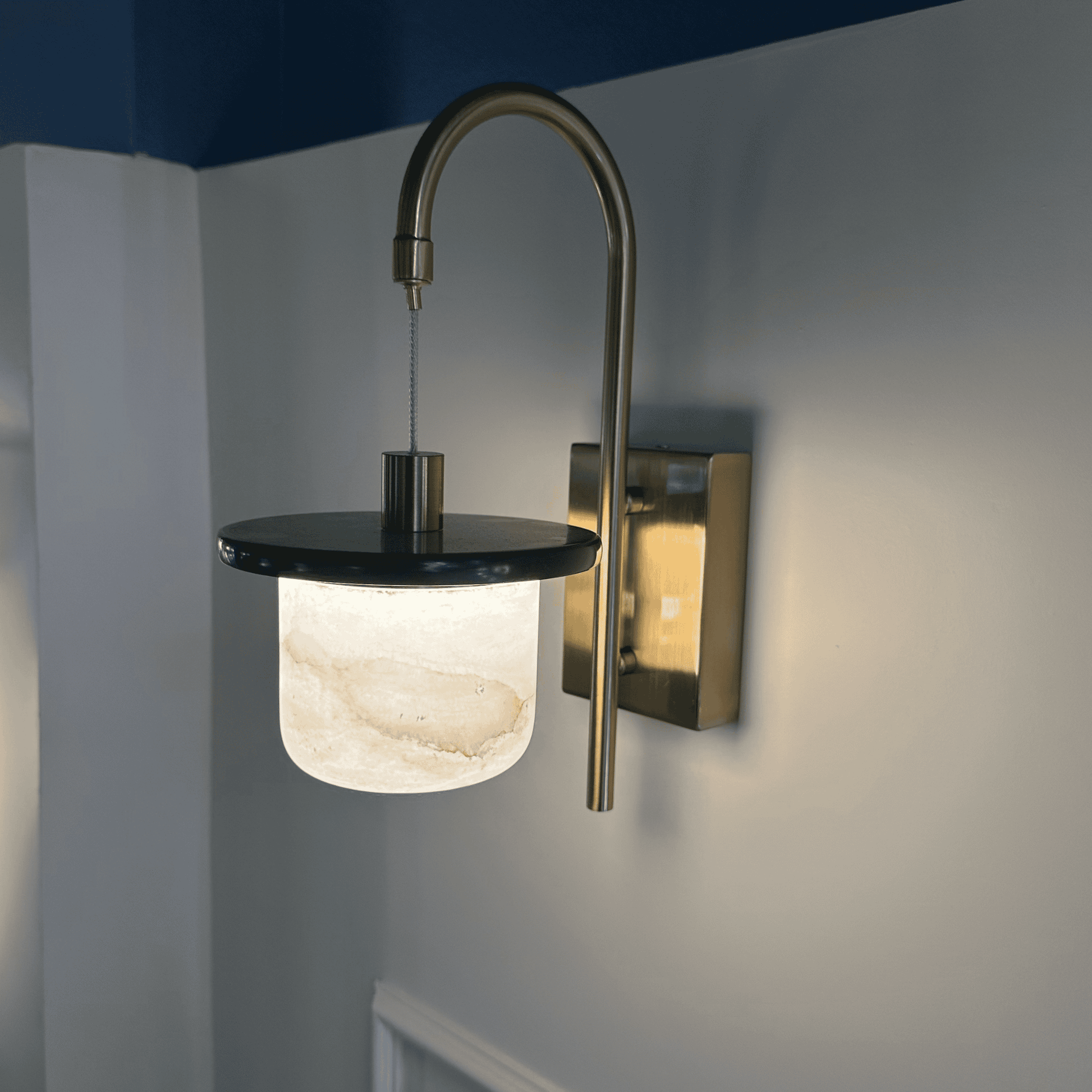 Marble sconce wall light with alabaster shade and brass detail.