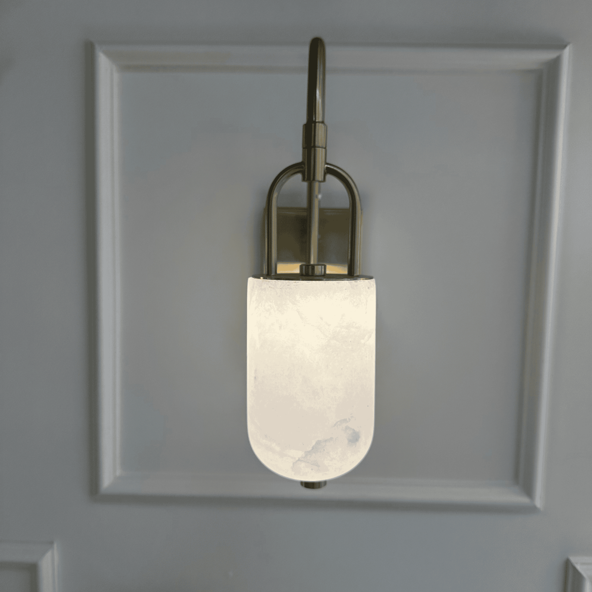 Front view of wall-mounted marble sconce with frosted alabaster and brass detailing.