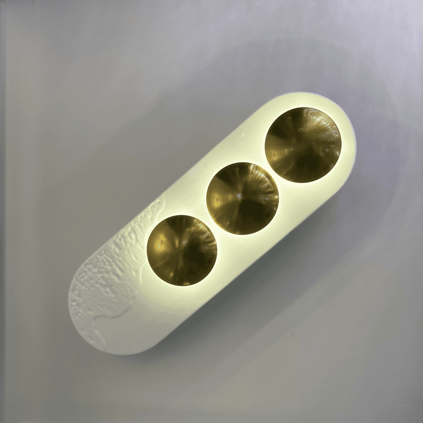 Contemporary white and brass minimalist LED wall sconce designed for modern interior spaces.