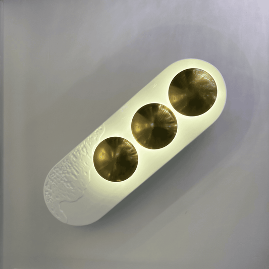 Contemporary white and brass minimalist LED wall sconce designed for modern interior spaces.
