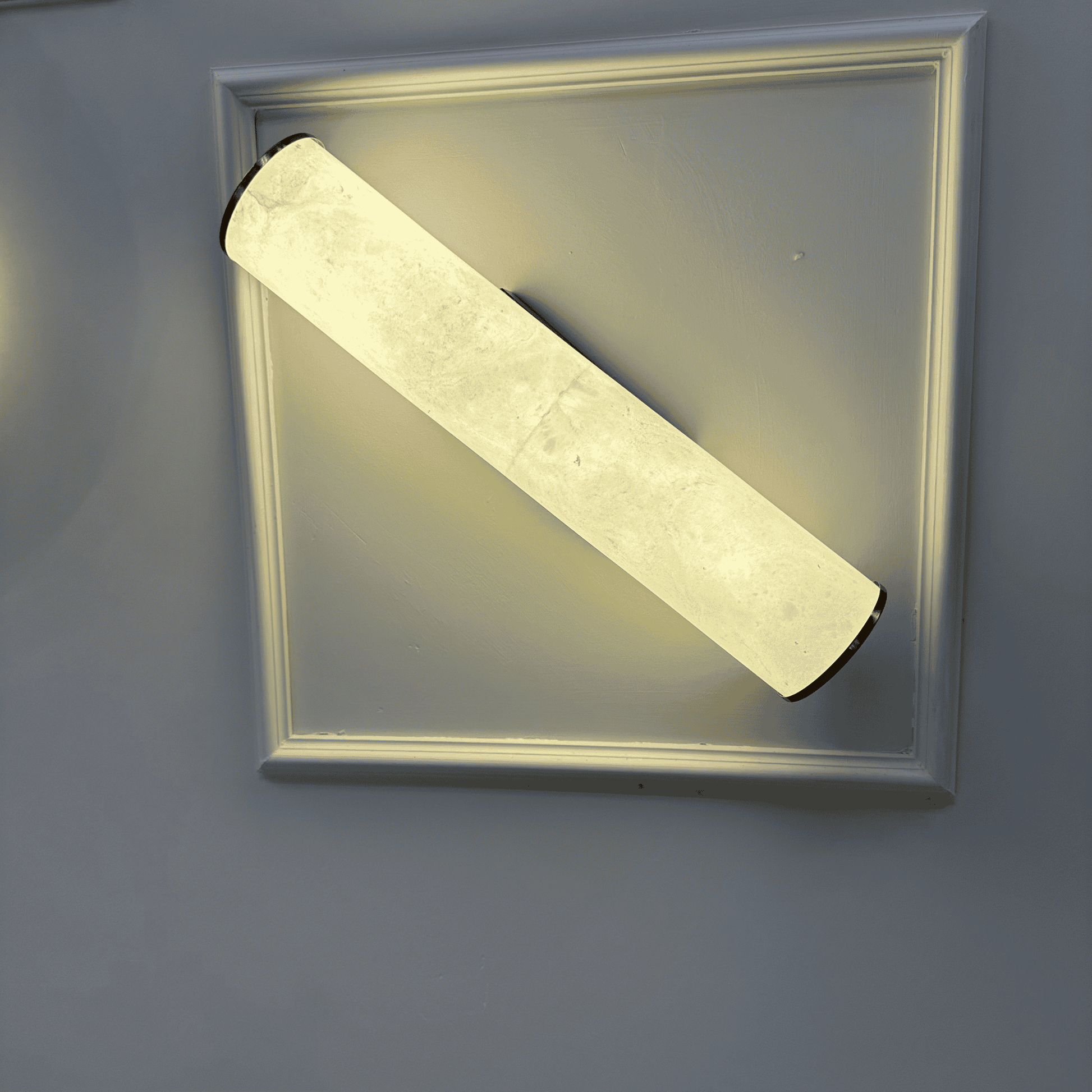 Minimalist horizontal alabaster wall sconce with natural stone texture and diffused glow.