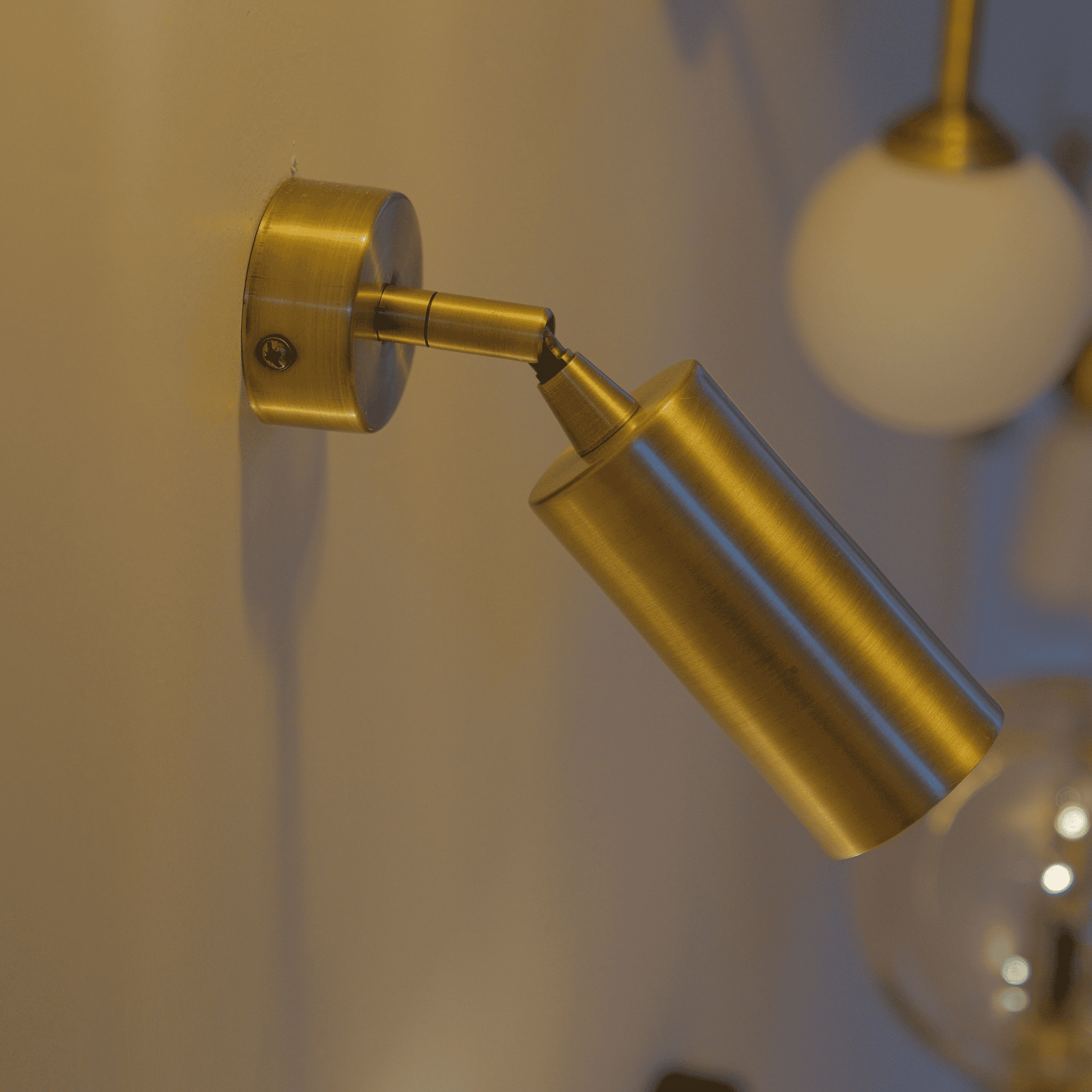 Modern brass wall spotlight sconce with LED glow for accent or task lighting.