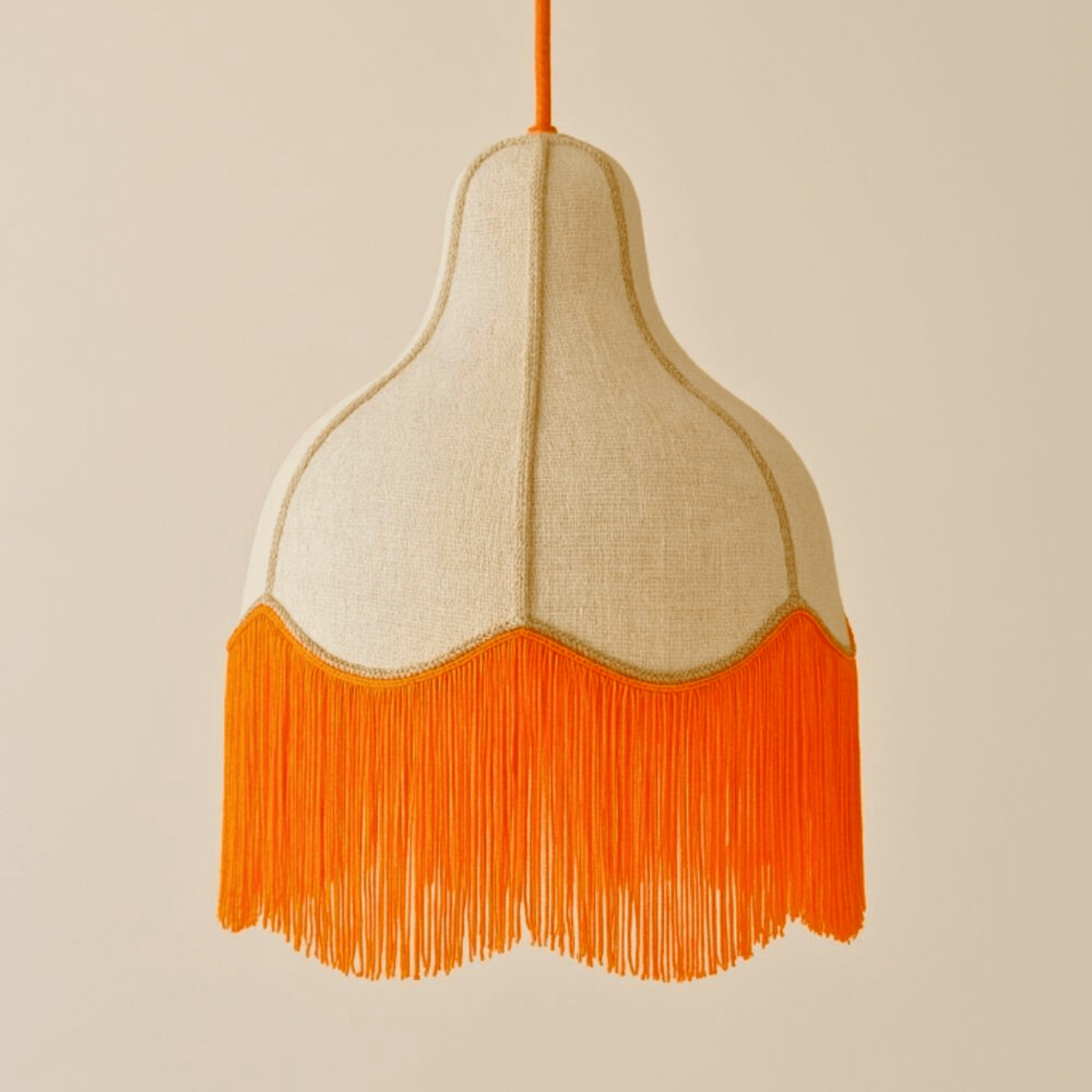 Retro-inspired pendant light with a natural linen shade and vibrant orange fringe, designed for stylish ceiling lighting.