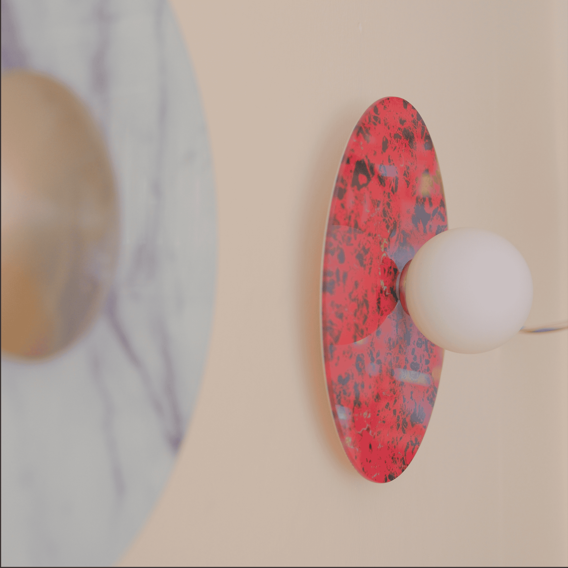 Hand holding red marbled backplate next to white marble backplate for modern wall sconce fixture.