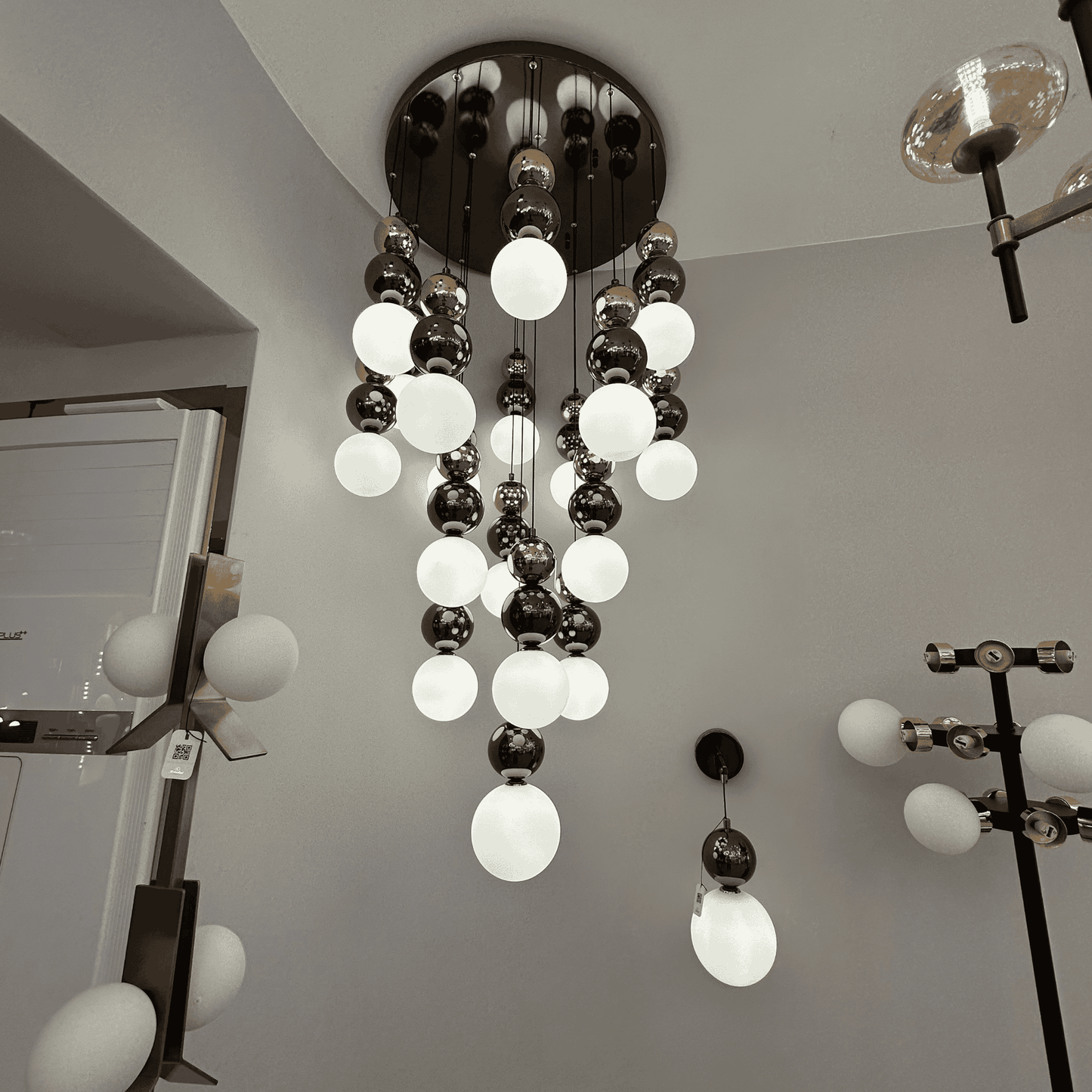 Cascading modern pendant lighting fixture with frosted and reflective glass globes for stylish interiors.