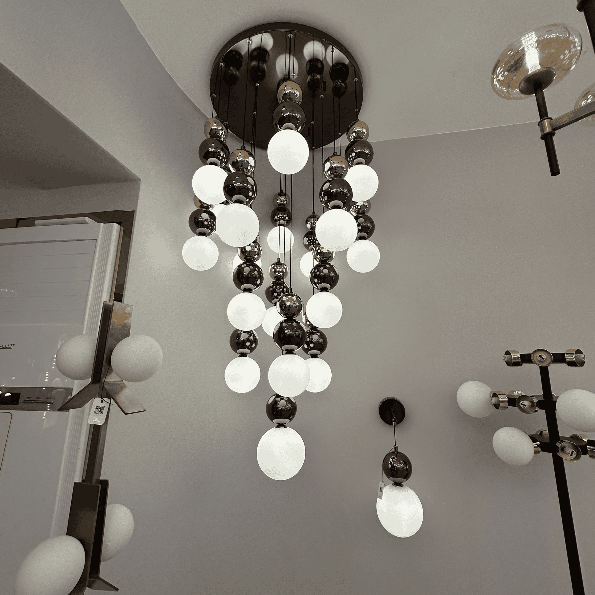 Cascading modern pendant lighting fixture with frosted and reflective glass globes for stylish interiors.