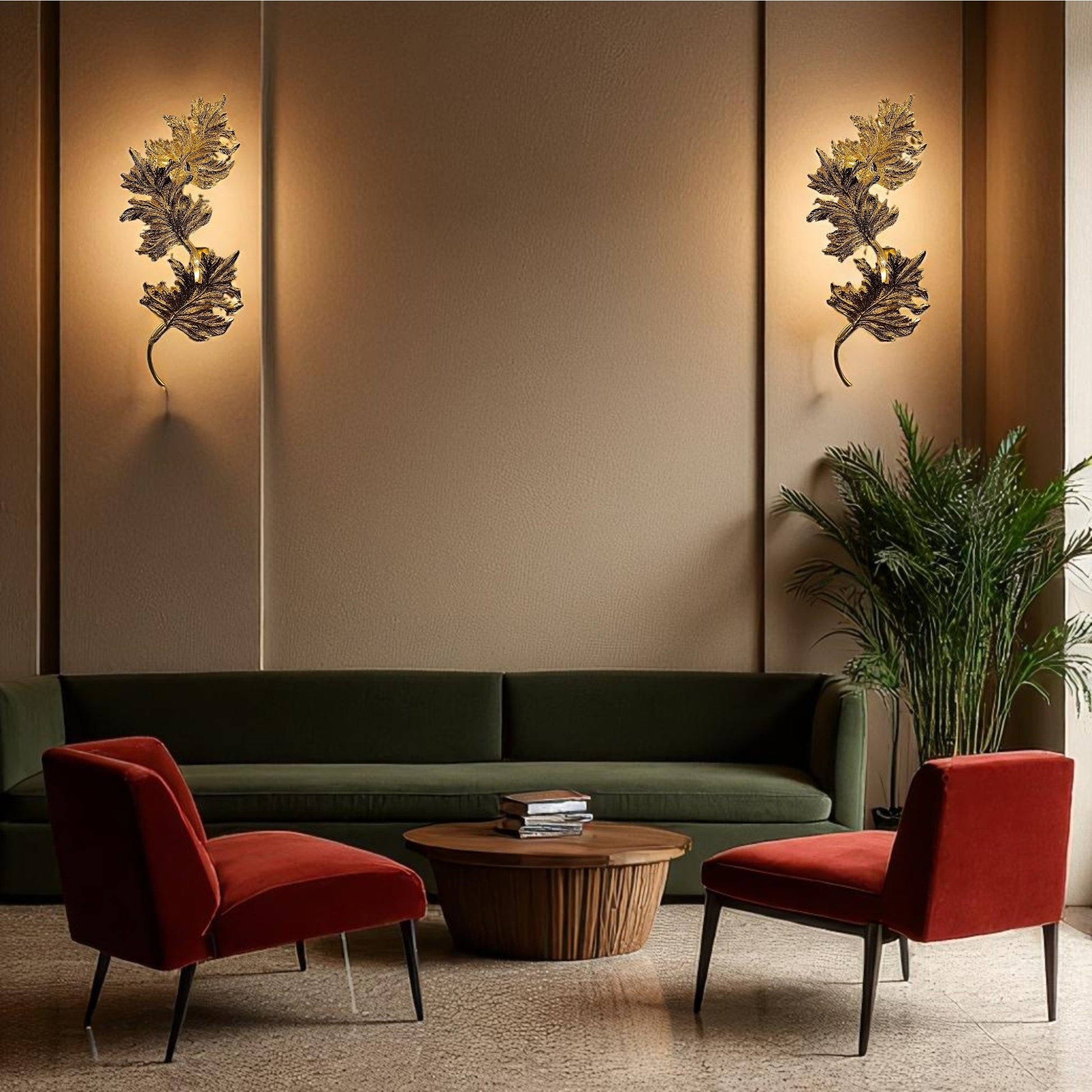 Pair of Verona gold sculptural leaf wall sconces mounted on a warm beige wall above a green sofa and red velvet chairs in a boutique hotel-style lounge