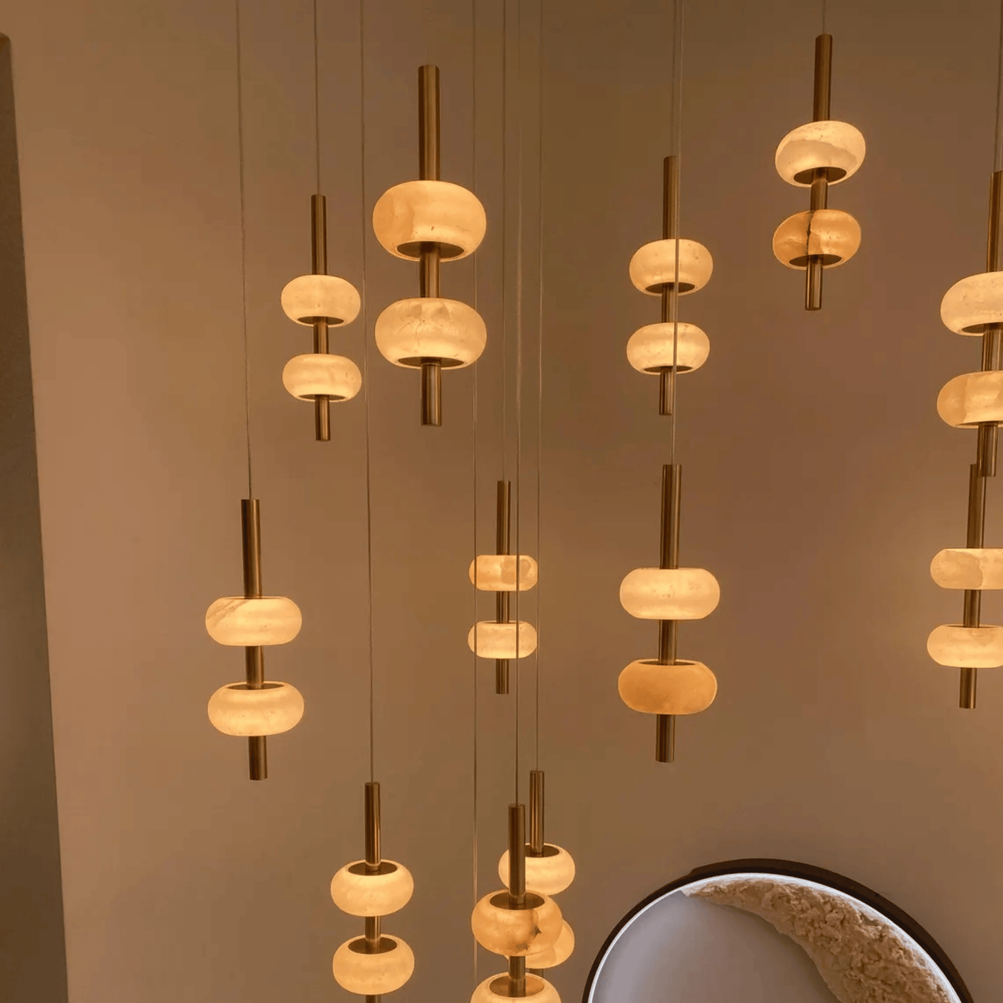 Multi-tier alabaster pendant lights casting warm ambient light in interior space.