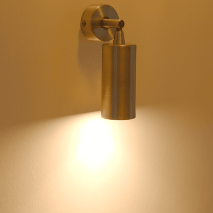 Adjustable brass wall sconce with cylindrical design providing focused spotlight illumination.