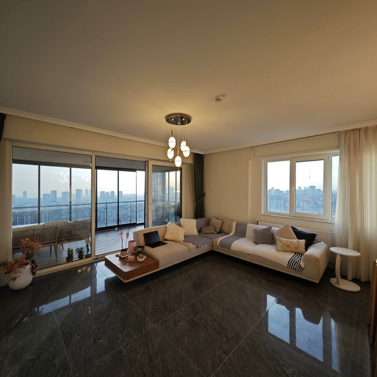 Alabaster pendant lights glowing softly over a dining table during dusk in a modern minimalist interior.