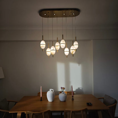 Evening lighting ambiance created by alabaster pendant lights suspended above a warm-toned dining area.