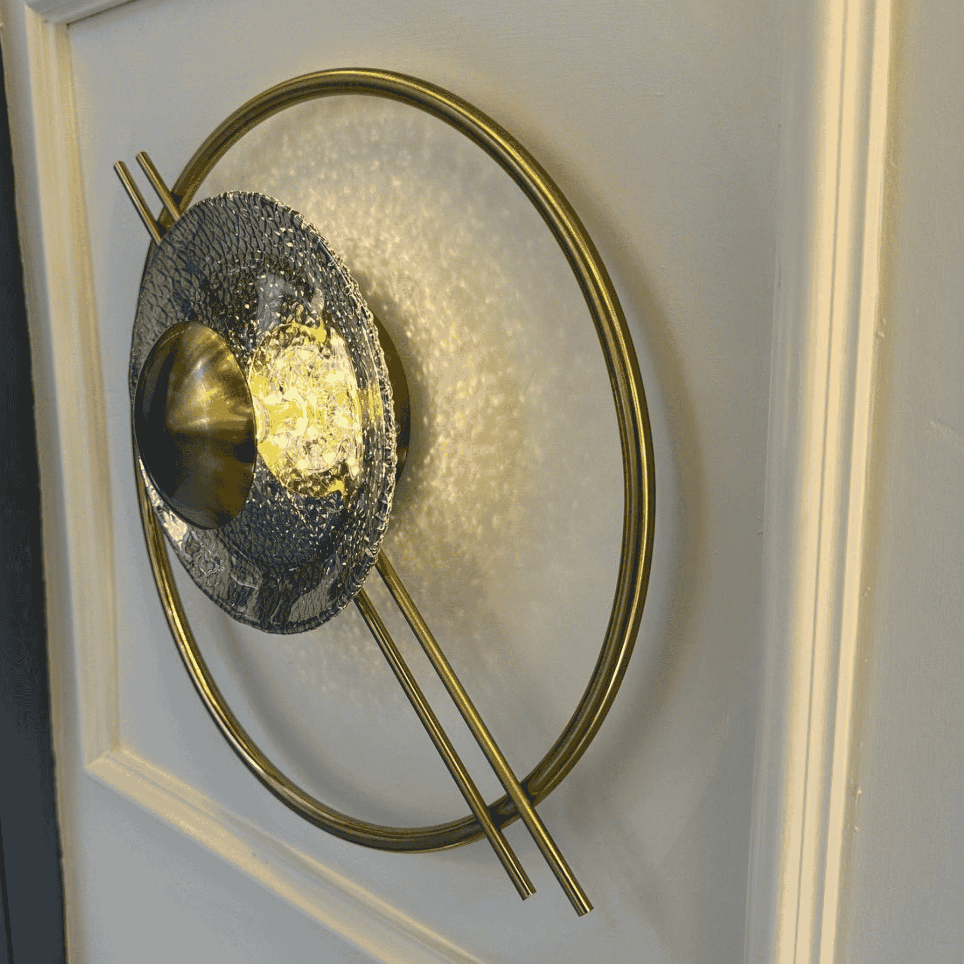 Brass and hammered glass wall light with circular Art Deco form, perfect for stairway applications.
