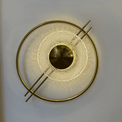 Brass and textured glass wall light emitting warm light, perfect for stairway use in Art Deco or Mid-Century settings.