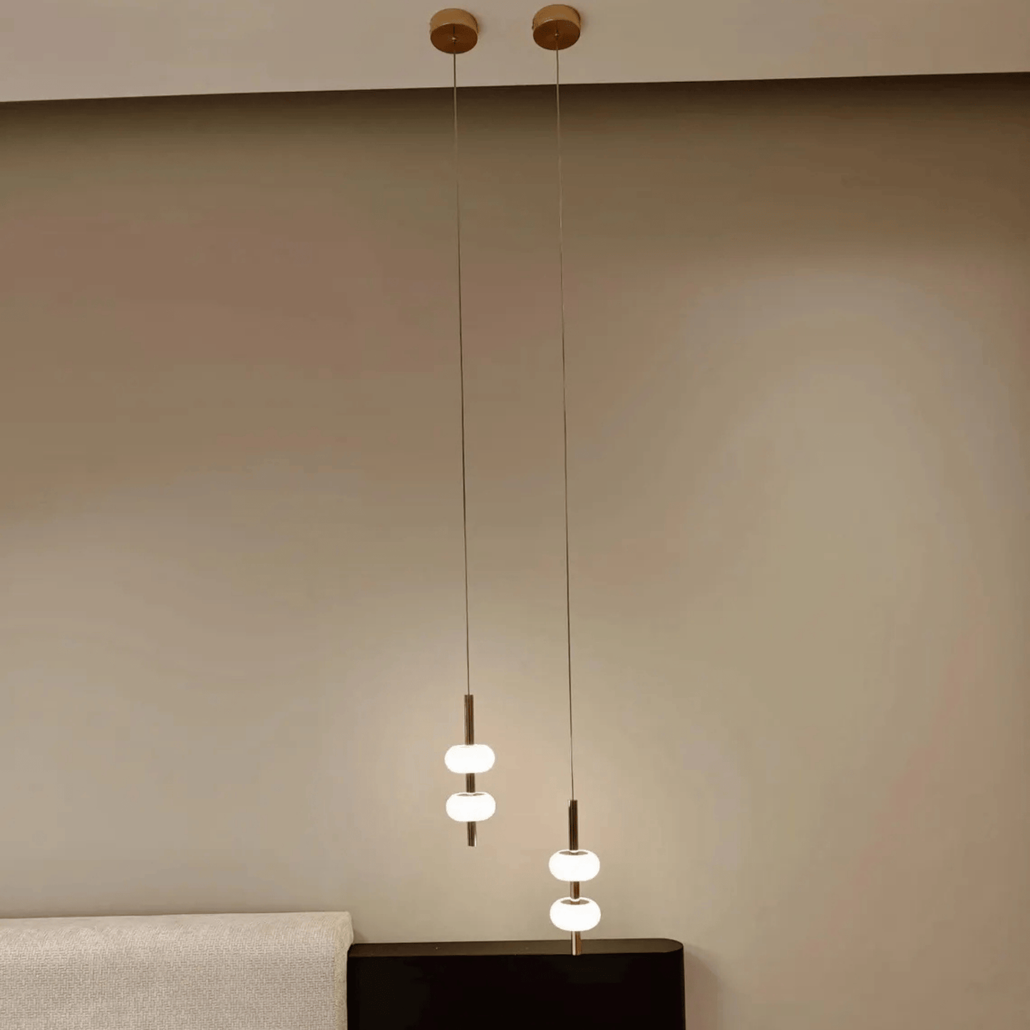 Minimalist ceiling-suspended alabaster pendant lights placed over bedside tables.