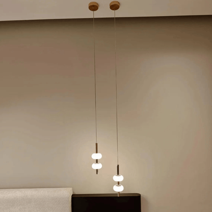Minimalist ceiling-suspended alabaster pendant lights placed over bedside tables.