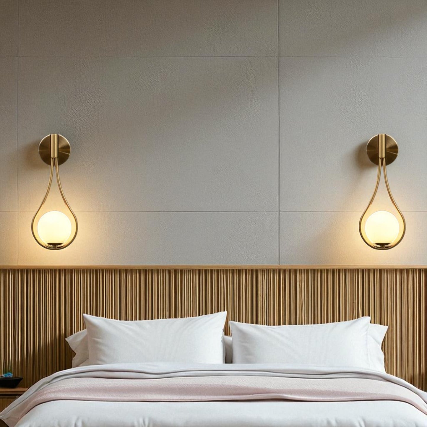 Modern bedroom with brass teardrop wall sconces mounted above a wooden headboard, casting soft ambient light.
