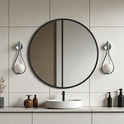 Chrome teardrop wall sconces on each side of a round mirror in a minimalist modern bathroom vanity setup.