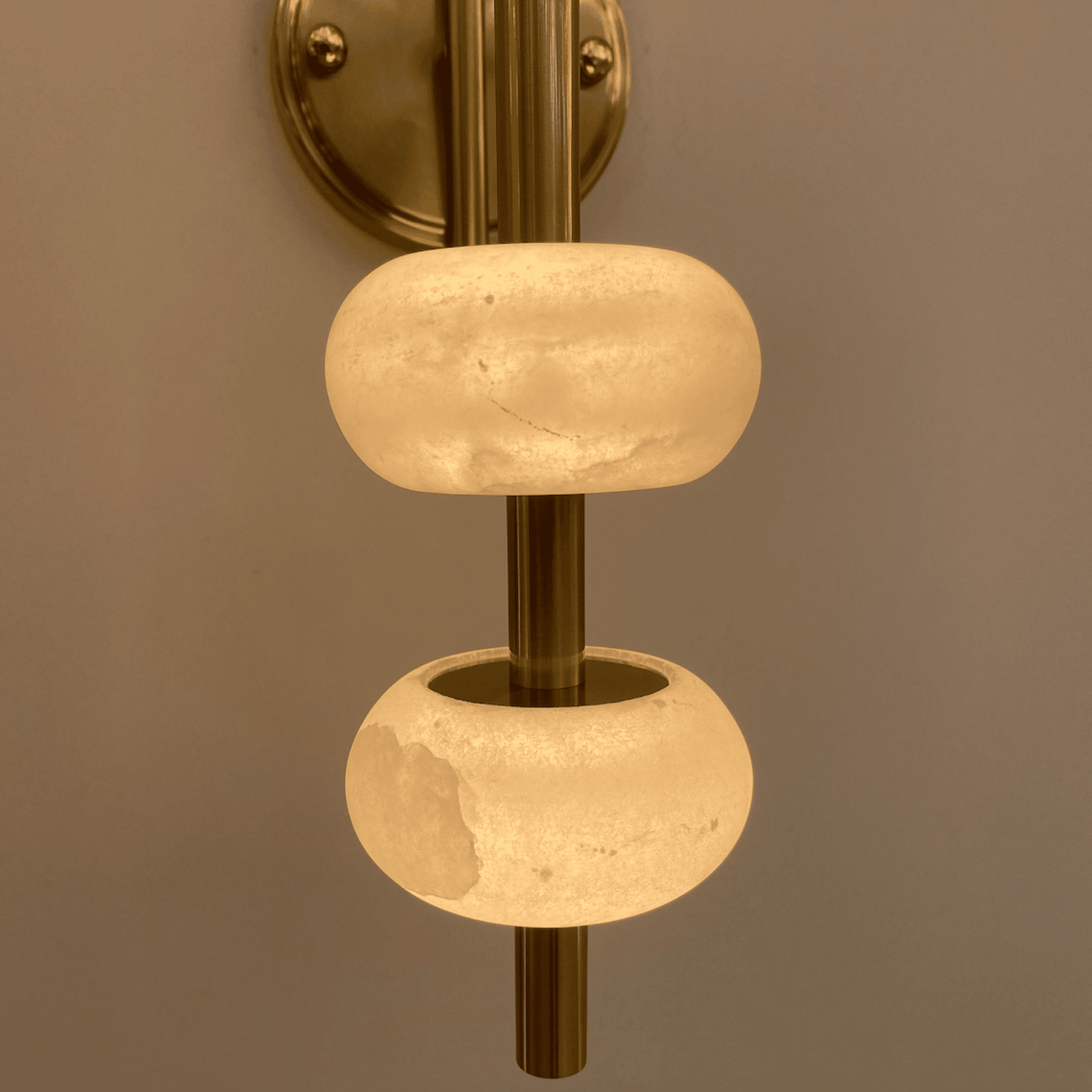 Close-up of brass wall light showing alabaster textures and warm lighting details.