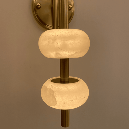 Close-up of brass wall light showing alabaster textures and warm lighting details.