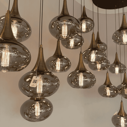 Close-up of hand-blown glass pendant lights with bronze fittings and visible filaments.