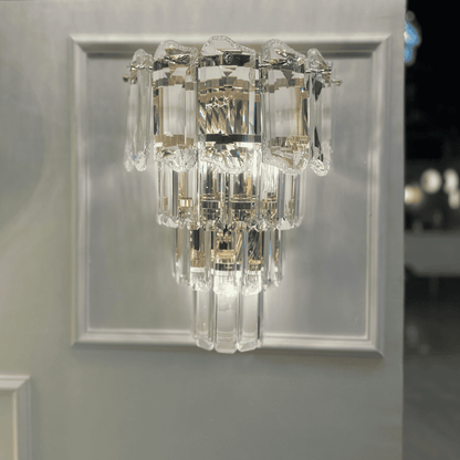 Contemporary crystal wall sconce light with a tiered clear glass structure and chrome base.
