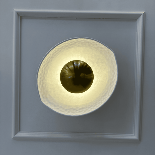 Decorative deco wall sconce with white hammered shade and golden reflective center viewed from the front.