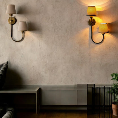 Dual fabric wall sconces with warm glow on a beige textured wall in a modern minimalist space