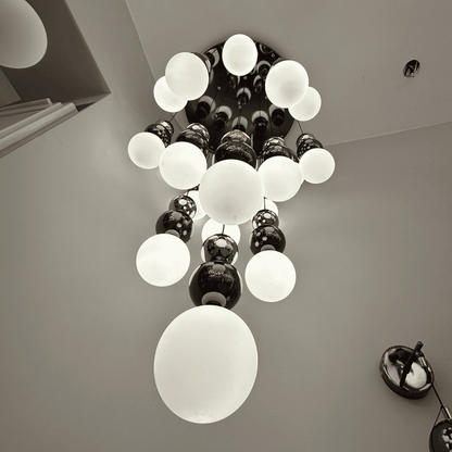 Upward view of a modern frosted glass globe pendant lighting fixture in a cascading chandelier design.