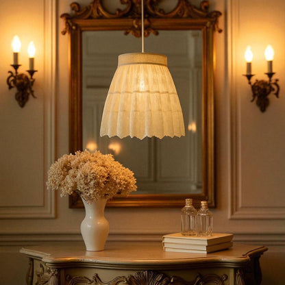 A glowing pendant lamp with lace fabric shade radiating warm ambient light in a soft vintage style.