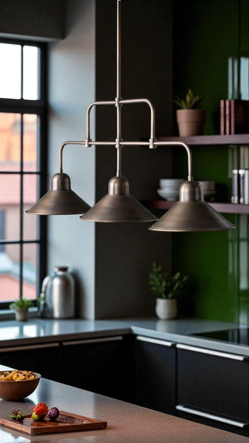 Industrial bronze triple pendant light hangs over a modern kitchen with black cabinets and green shelving.