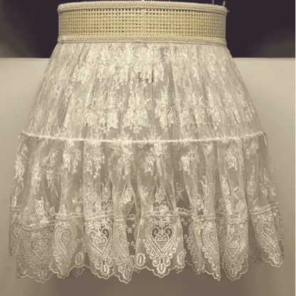Close-up of a vintage-style lace pendant light with sheer floral embroidery and woven trim for elegant boho lighting.