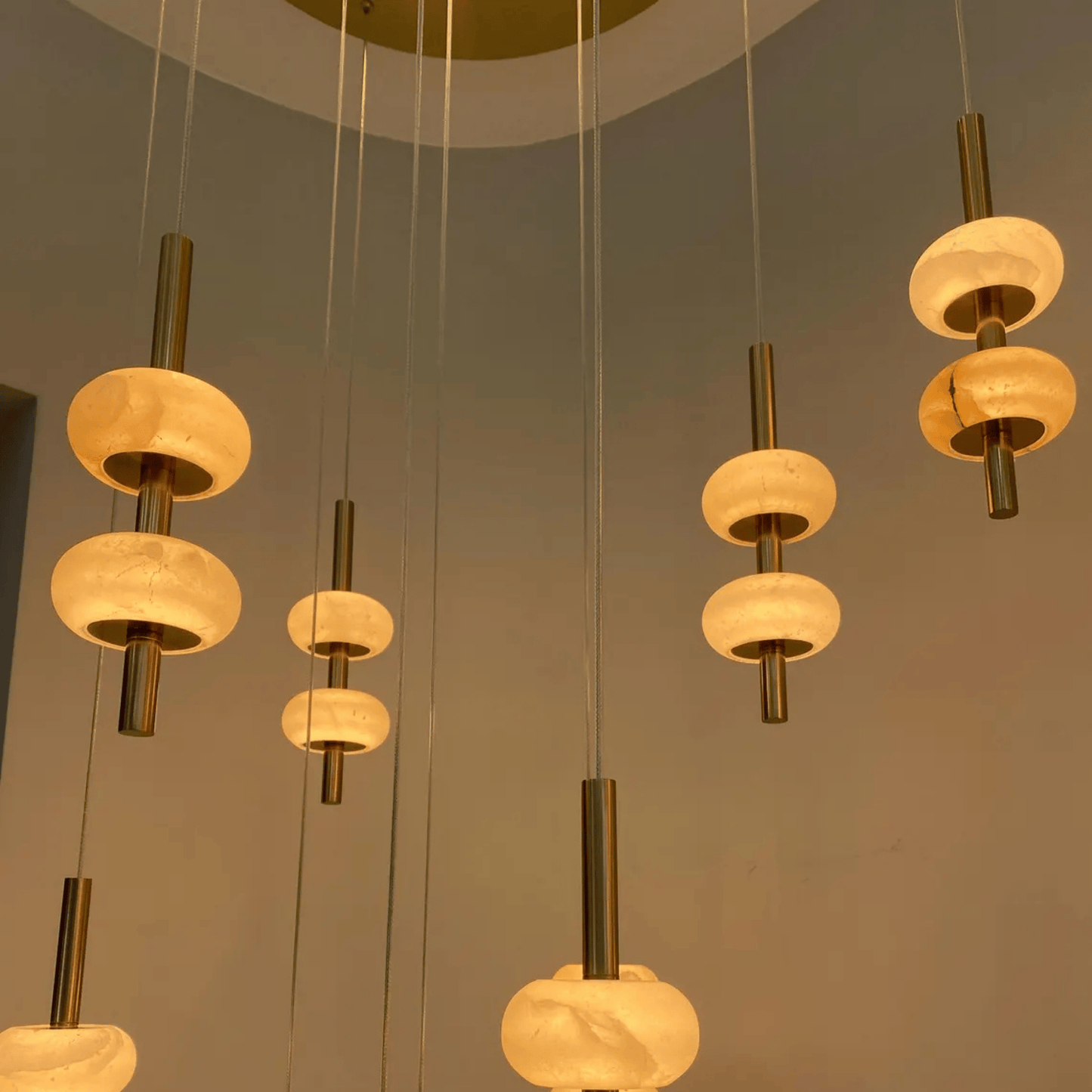 Hanging alabaster globe pendant lights with metal rods creating a layered lighting design.