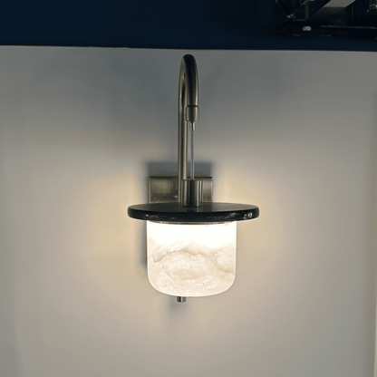 Glowing marble sconce wall light with alabaster shade seen from the front.