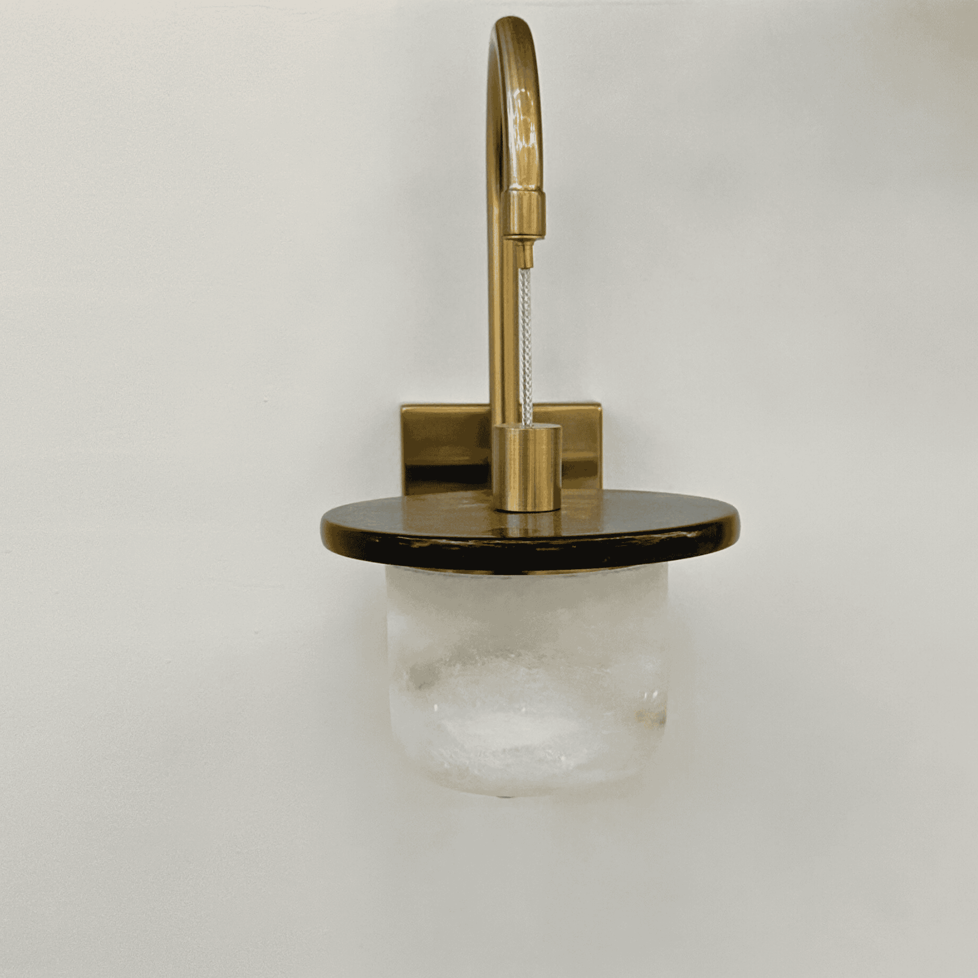 Unlit marble sconce wall light with alabaster shade and brass mounting.