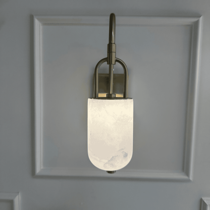 Front view of wall-mounted marble sconce with frosted alabaster and brass detailing.