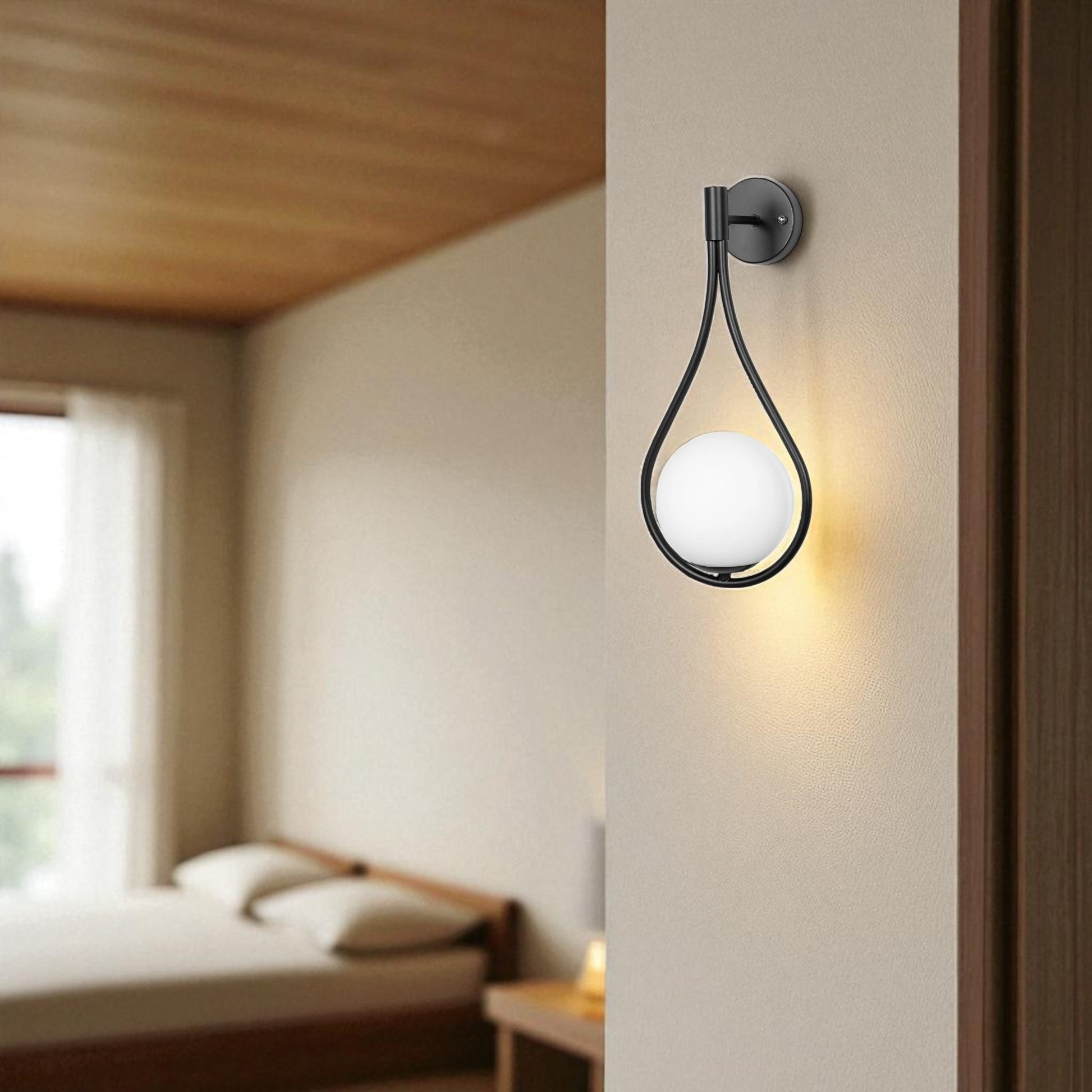 Minimalist matte black teardrop wall sconce with white globe, mounted on a bedroom wall.