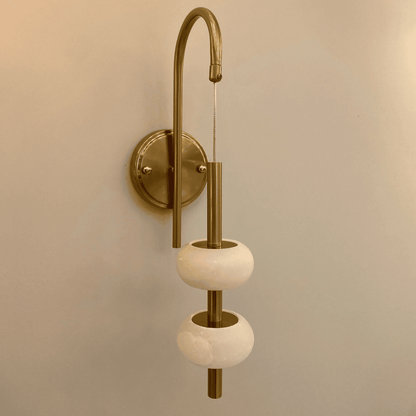 Unlit brass wall light with two alabaster rings in a clean, minimalistic modern style.