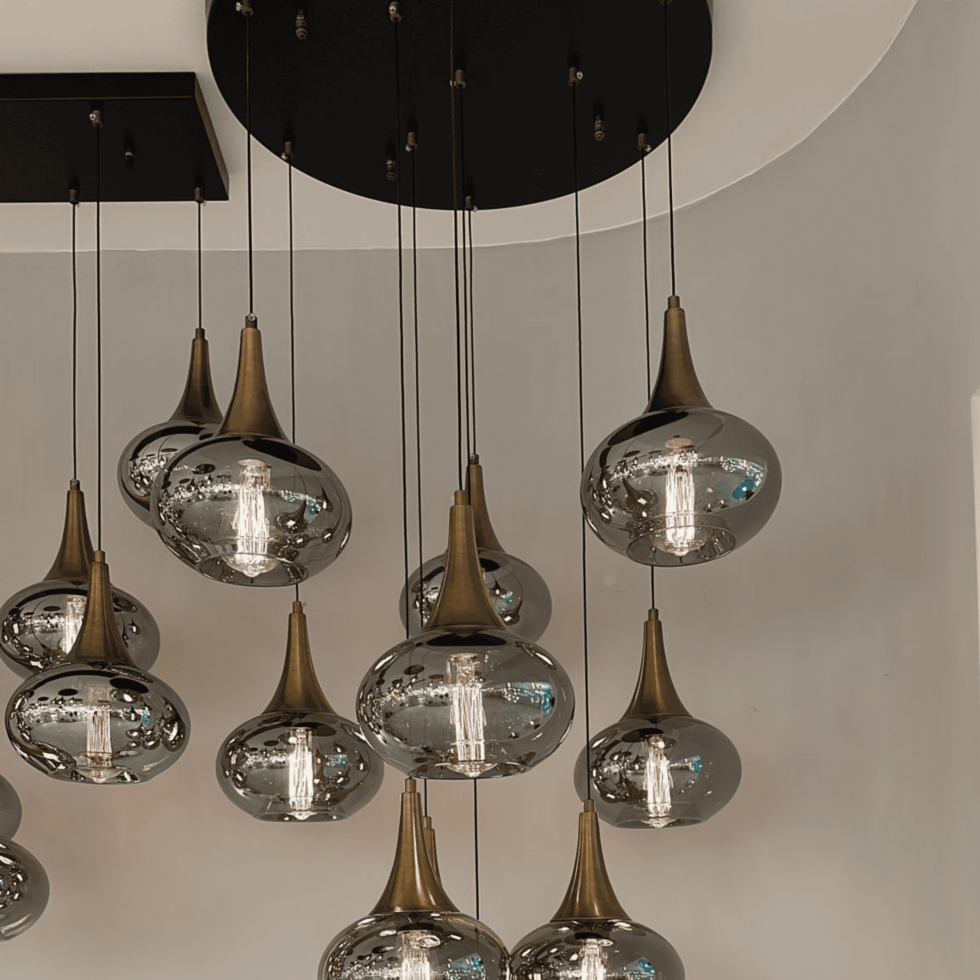 Bronze conical pendant lighting with transparent glass globes and exposed bulbs.